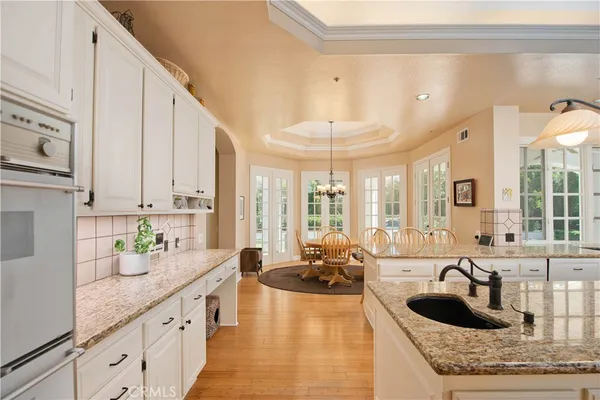 a large kitchen with granite countertop a large counter top a sink and cabinets
