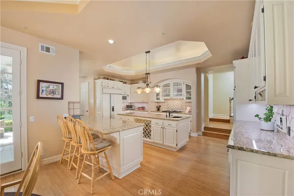 a kitchen with granite countertop cabinets a dining table and chairs