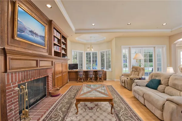 a living room with furniture a fireplace and large windows