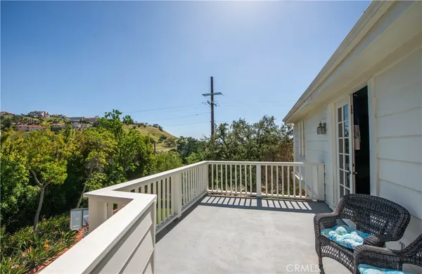 a view of a chair and tables in the balcony