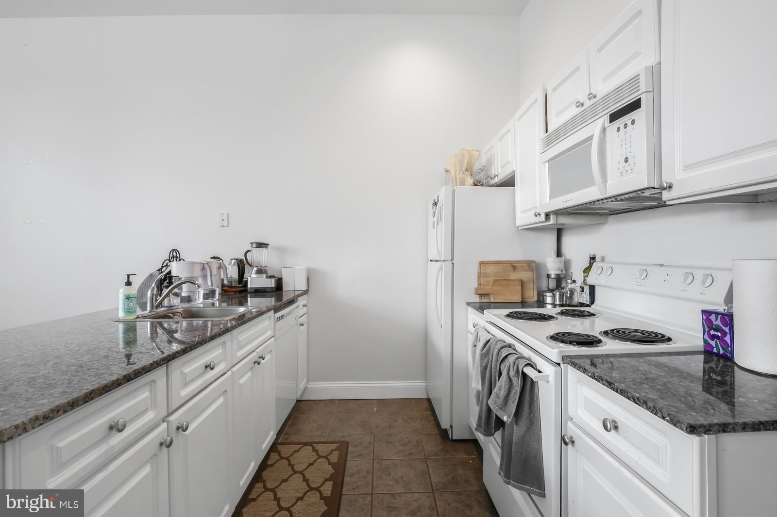1001 Chestnut Street, Unit 903W Philadelphia, PA 19103 - Photo 3 of 21 a kitchen with stainless steel appliances granite countertop a sink stove and cabinets
