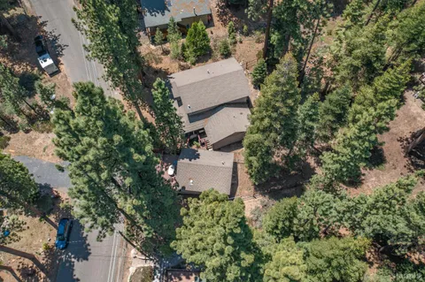 an aerial view of a house with a yard and large tree