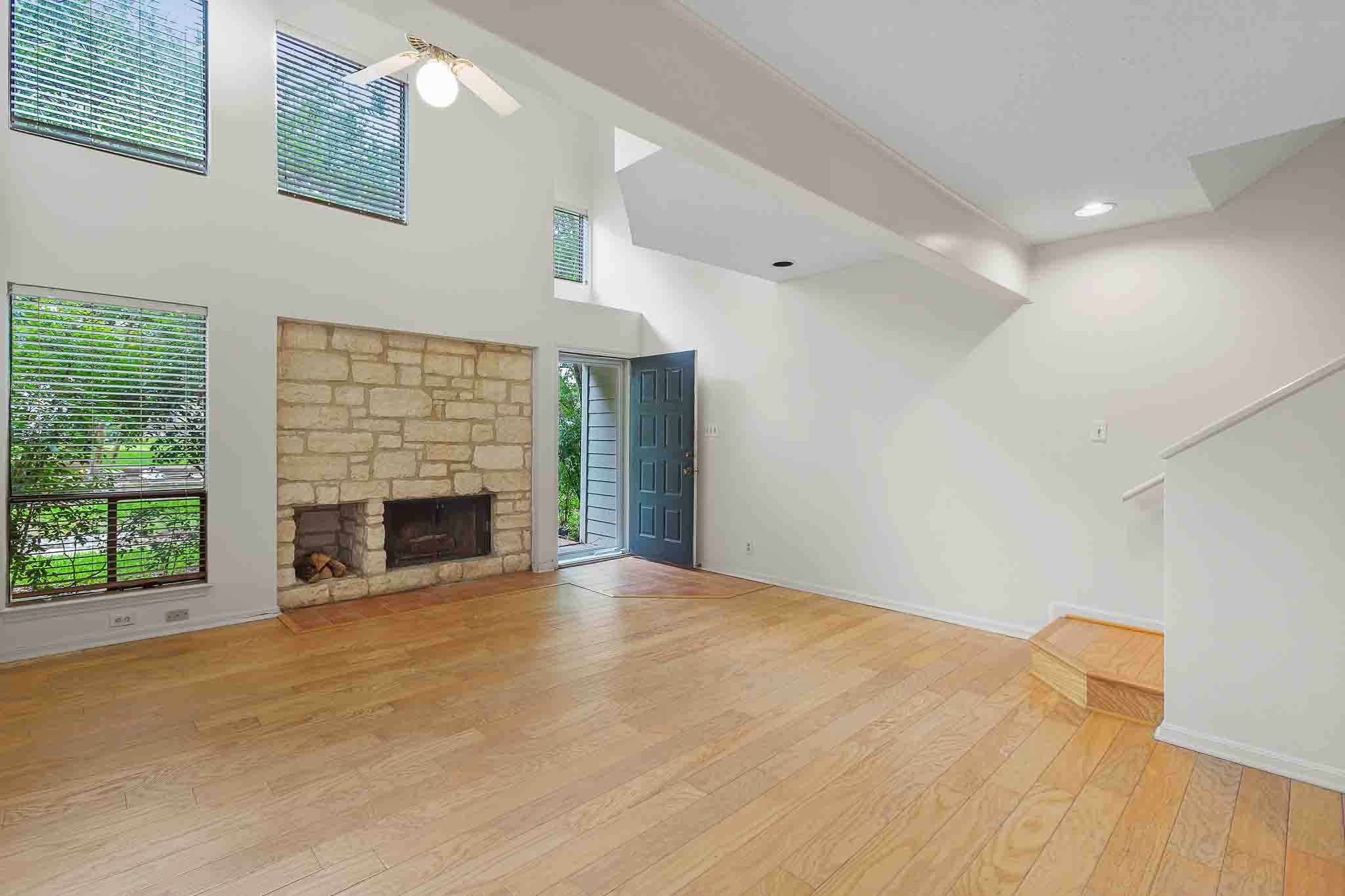 9226 Jollyville Road, Unit 132 Austin, TX 78759 - Photo 4 of 15 A spacious living area with soaring ceilings and a floor-to-ceiling stone fireplace.