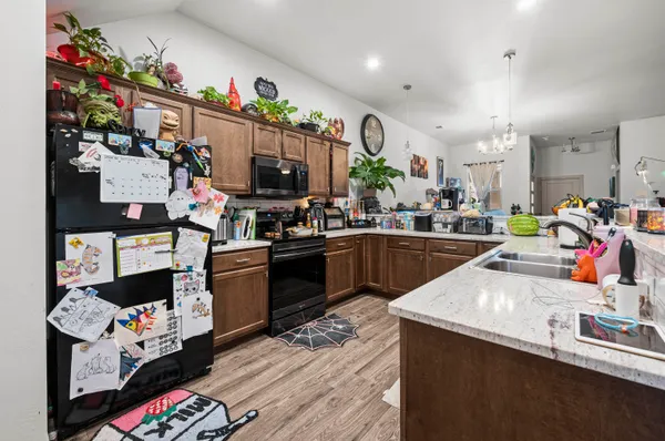 a kitchen filled with lots of clutter and cabinets