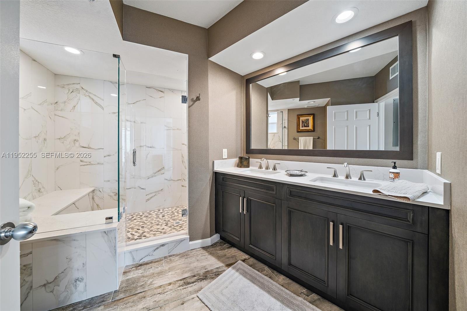 5800 Northeast Island Cove Way, Unit 2207 Stuart, FL 34996 - Photo 12 of 27 a bathroom with a double vanity sink mirror and bathtub