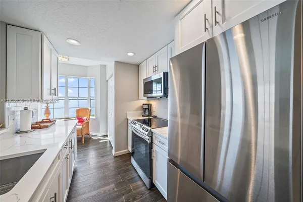 a kitchen with stainless steel appliances granite countertop a sink and a refrigerator