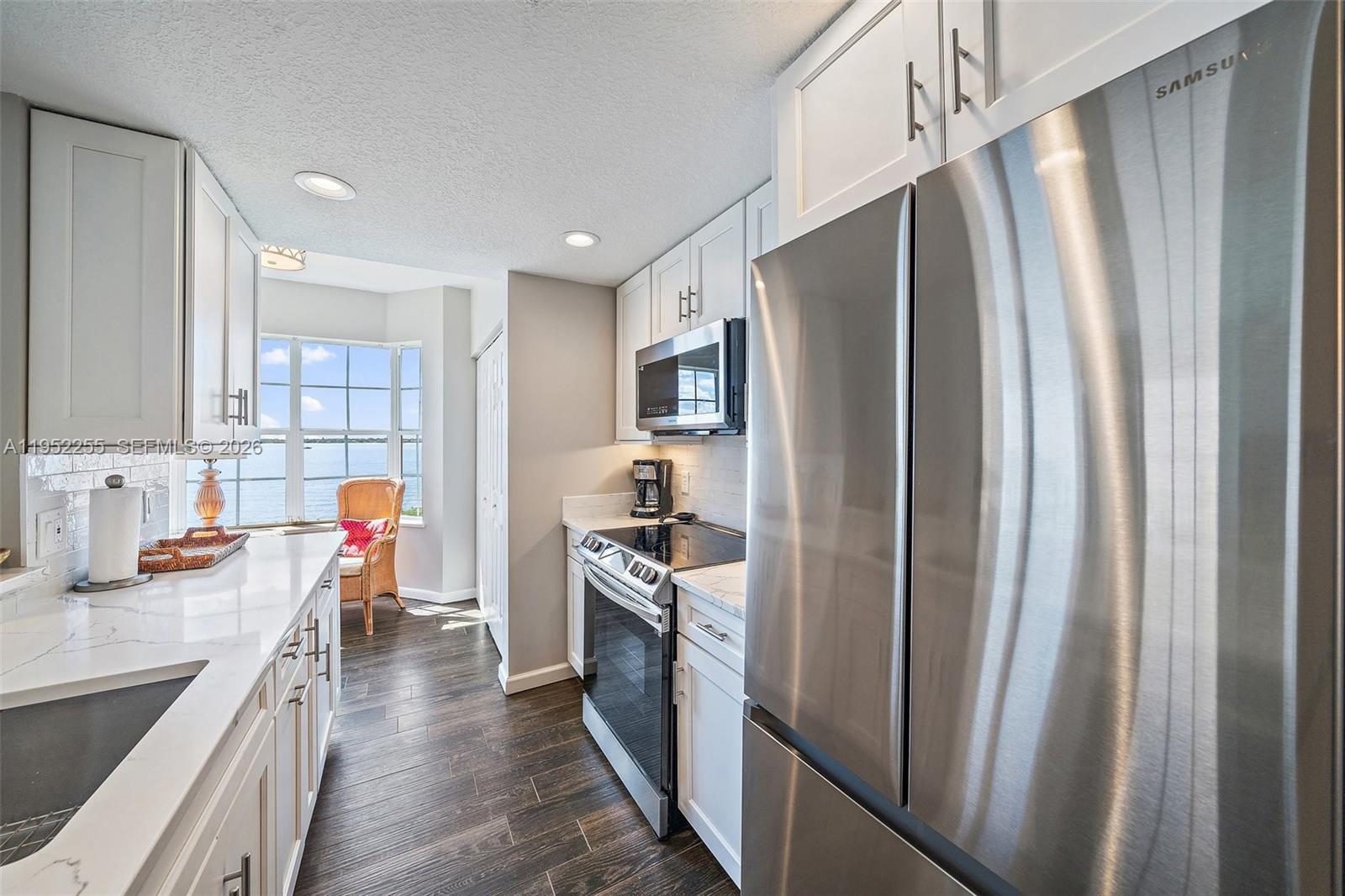 5800 Northeast Island Cove Way, Unit 2207 Stuart, FL 34996 - Photo 5 of 27 a kitchen with stainless steel appliances granite countertop a refrigerator and a sink