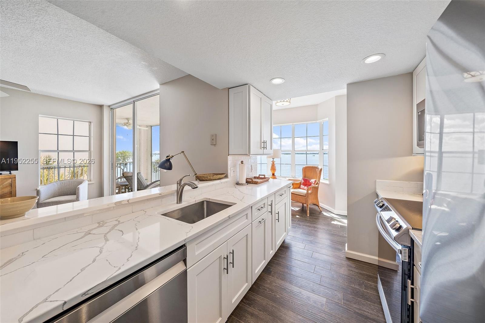5800 Northeast Island Cove Way, Unit 2207 Stuart, FL 34996 - Photo 6 of 27 a kitchen with stainless steel appliances granite countertop a sink and a refrigerator