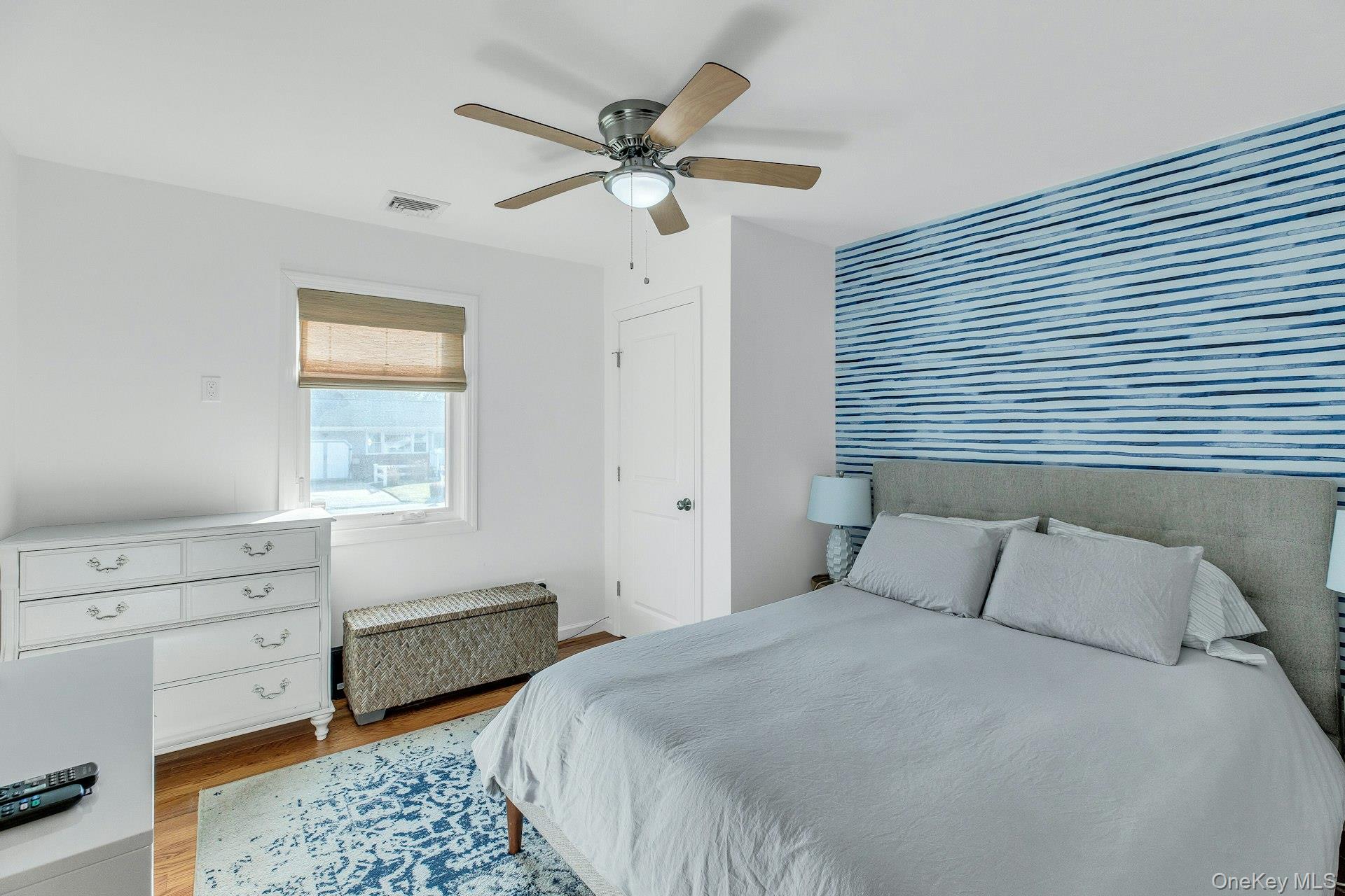 79 School Street Hampton Bays, NY 11946 - Photo 13 of 49 a bedroom with a bed and a dresser