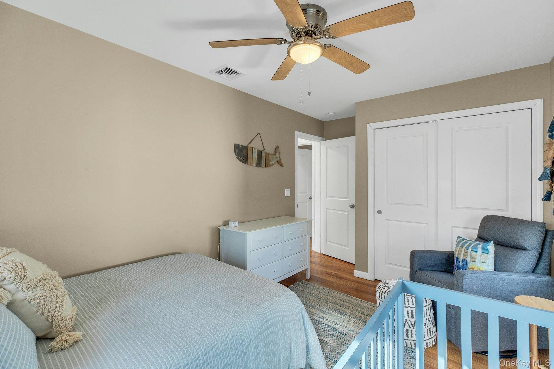 79 School Street Hampton Bays, NY 11946 - Photo 15 of 49 a bedroom with a bed and a chandelier