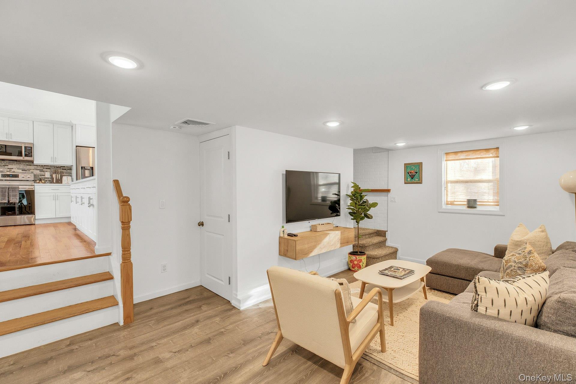 79 School Street Hampton Bays, NY 11946 - Photo 17 of 49 a living room with furniture and a flat screen tv