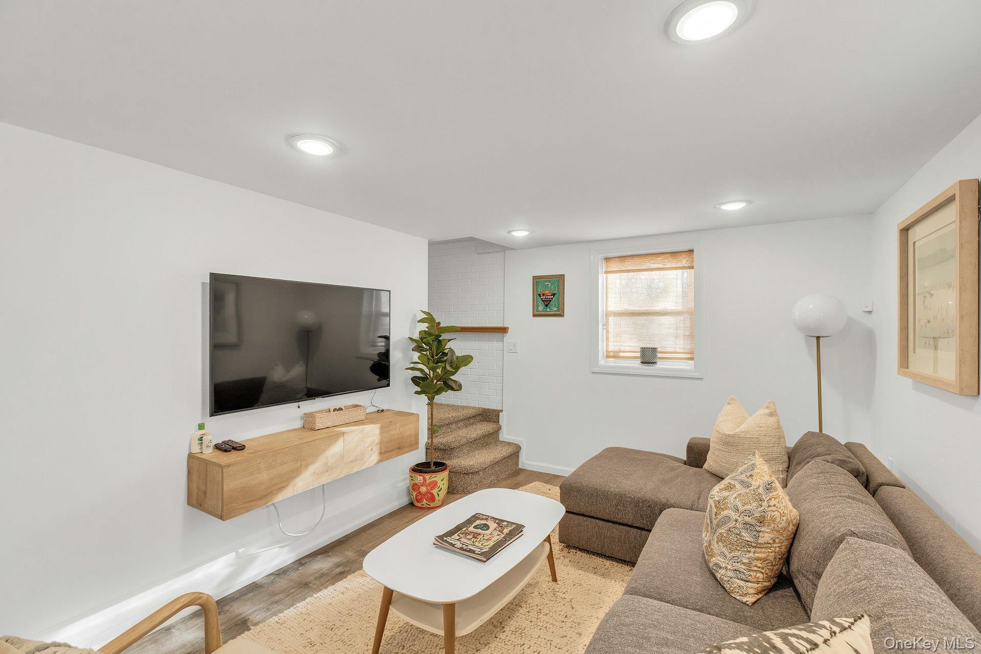 79 School Street Hampton Bays, NY 11946 - Photo 18 of 49 a living room with furniture and a flat screen tv