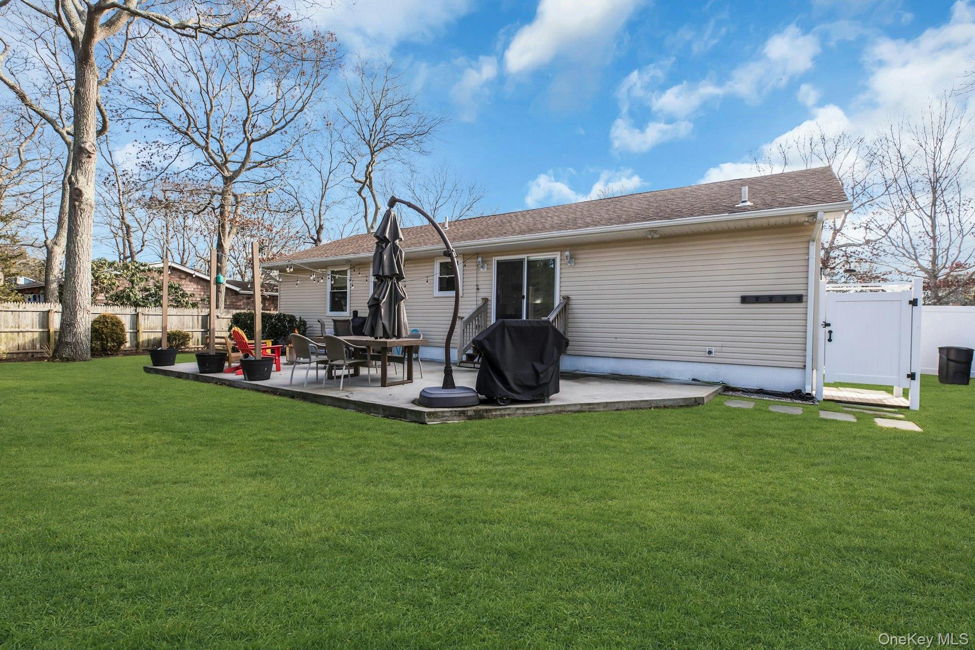 79 School Street Hampton Bays, NY 11946 - Photo 26 of 49 a view of a patio with table and chairs and a fire pit