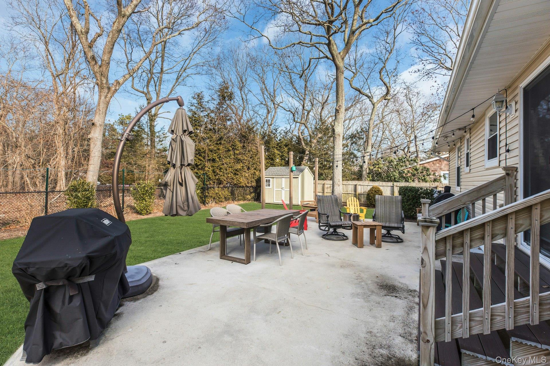 79 School Street Hampton Bays, NY 11946 - Photo 28 of 49 a view of backyard with outdoor seating and trees