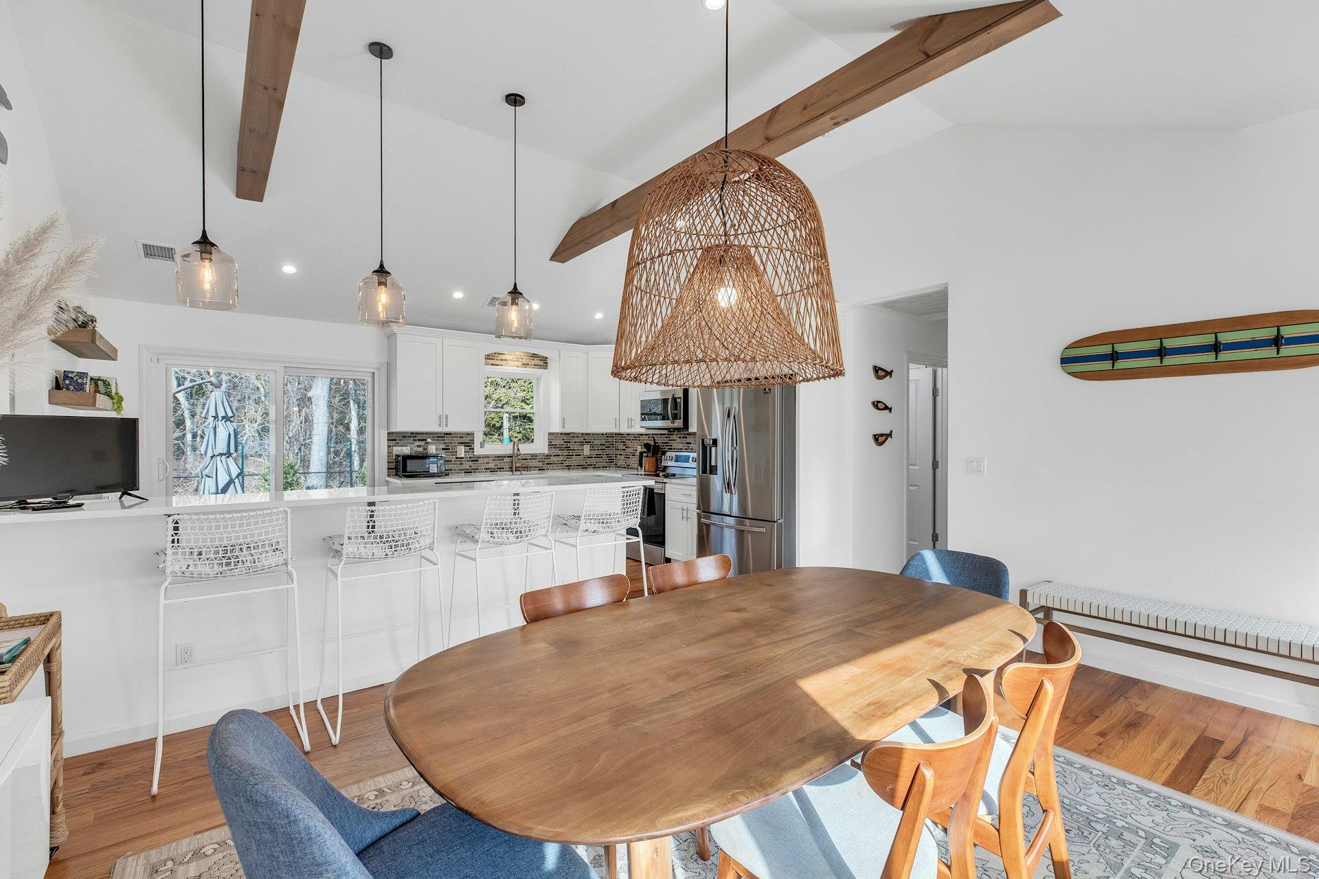 79 School Street Hampton Bays, NY 11946 - Photo 6 of 49 a kitchen with stainless steel appliances kitchen island granite countertop a table and chairs in it
