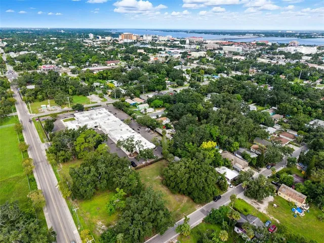 an aerial view of residential houses with outdoor space and trees