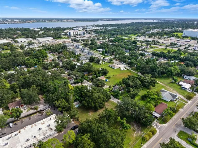 an aerial view of residential houses with outdoor space and trees