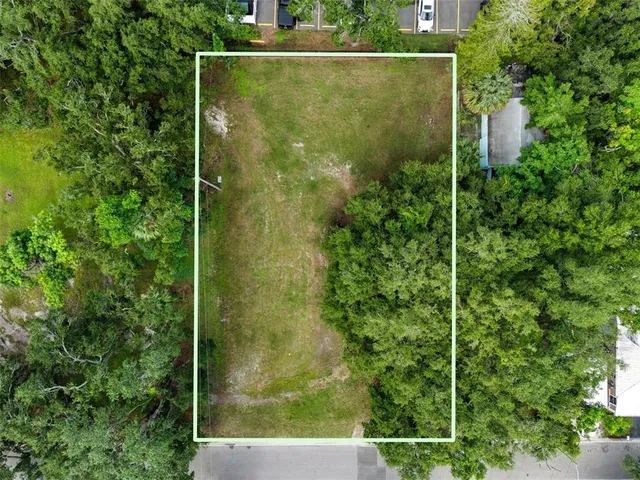 an aerial view of residential house with outdoor space and trees all around