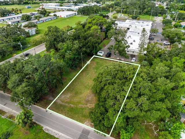 an aerial view of residential houses with outdoor space and trees