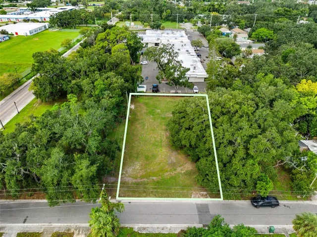 an aerial view of residential houses with outdoor space and trees