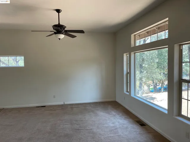 a view of a room with a window and a ceiling fan
