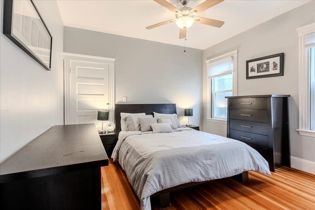 213 Reservoir Road, Unit 1 Brookline, MA 02467 - Photo 28 of 40 a bedroom with a bed and a chandelier
