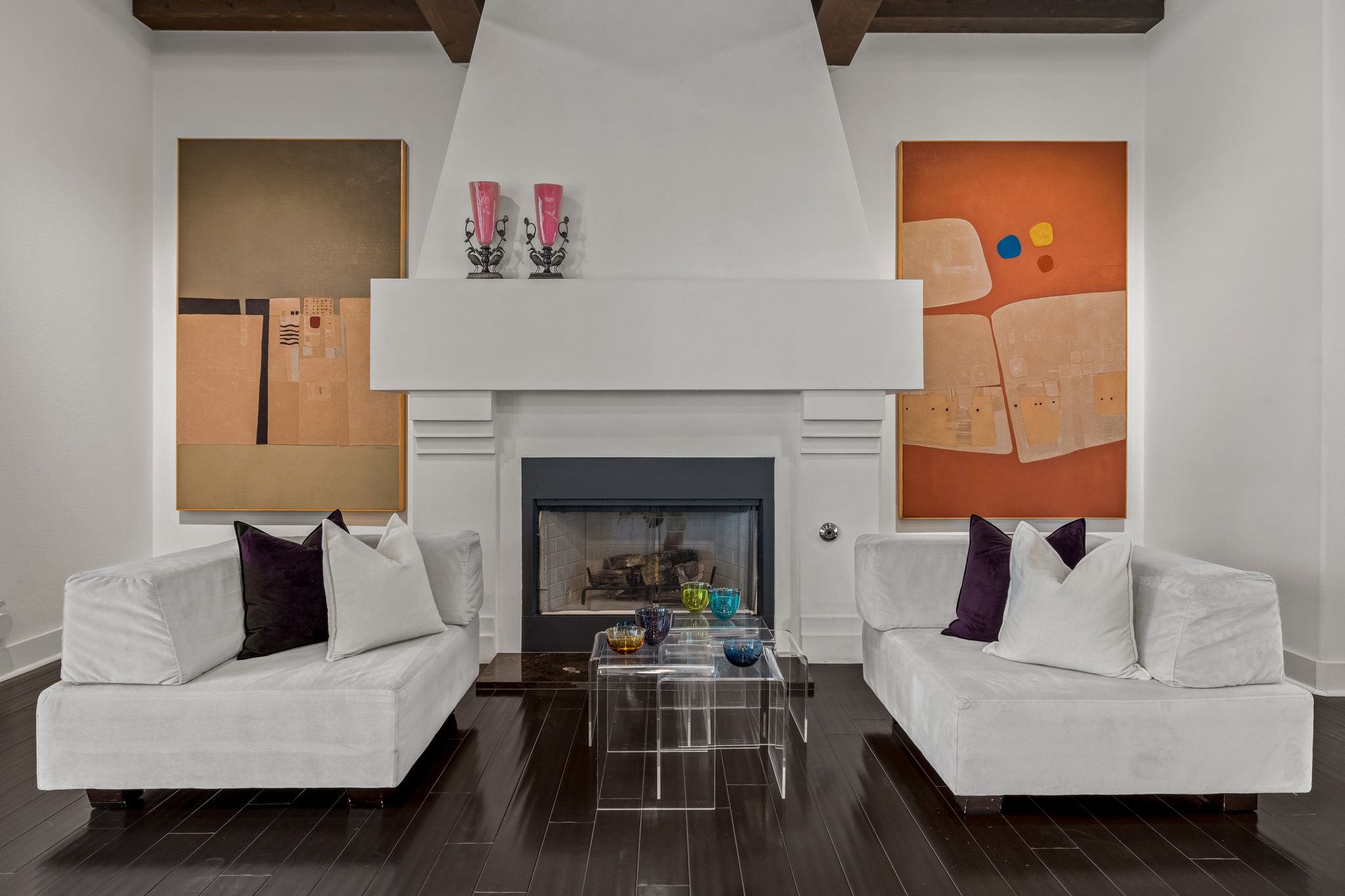 4720 Rockcliff Road, Unit 1 Austin, TX 78746 - Photo 13 of 39 Exposed beams complement a grand fireplace, anchoring a refined living space with rich hardwood flooring.