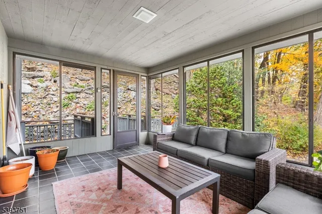 a living room with furniture a rug and a large window