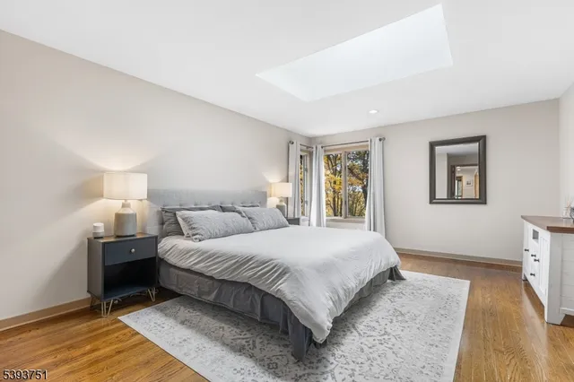a bedroom with a bed lamp on table and a window