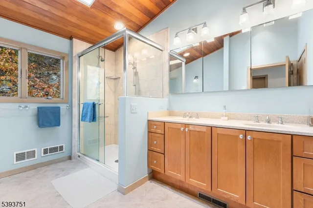 a bathroom with a sink a mirror and a shower