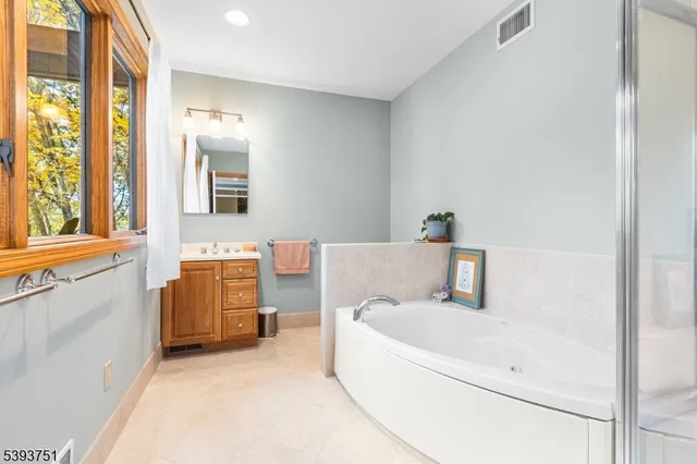 a en suite bathroom with a tub sink and mirror