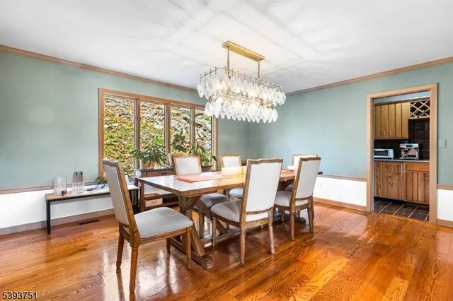 a dining room with furniture a chandelier and wooden floor