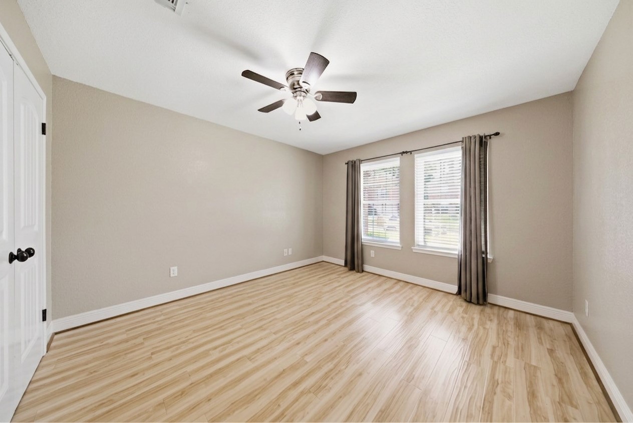 13506 Spring Court Tomball, TX 77375 - Photo 22 of 37 an empty room with wooden floor fan and windows