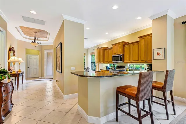 a kitchen with stainless steel appliances granite countertop a stove top oven a sink dishwasher and white cabinets with wooden floor