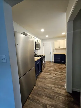 a large kitchen with a refrigerator and a sink