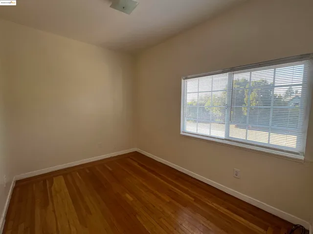 a view of a room with wooden floor and a window