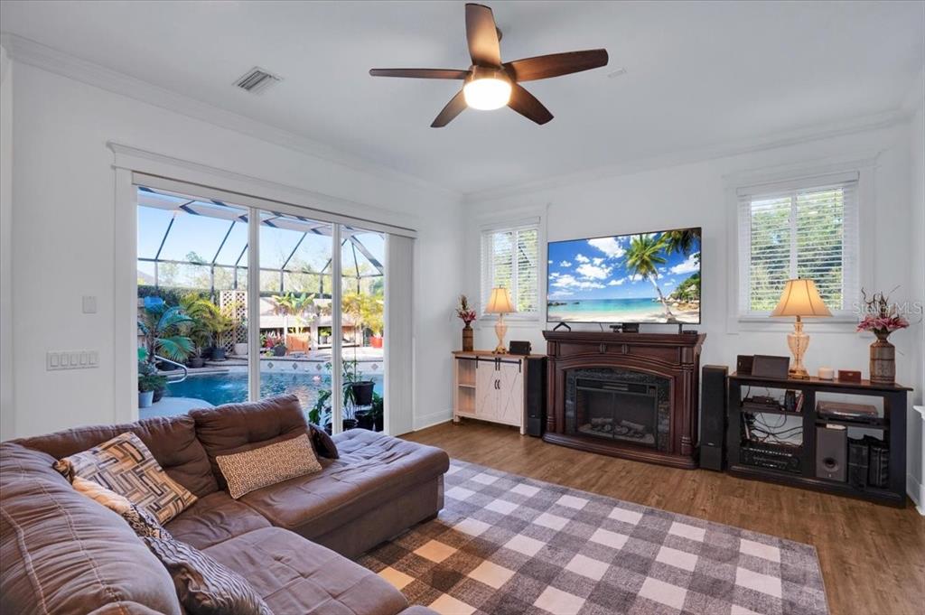 7601 226th Street East Bradenton, FL 34211 - Photo 13 of 50 a living room with furniture a large window and a flat screen tv