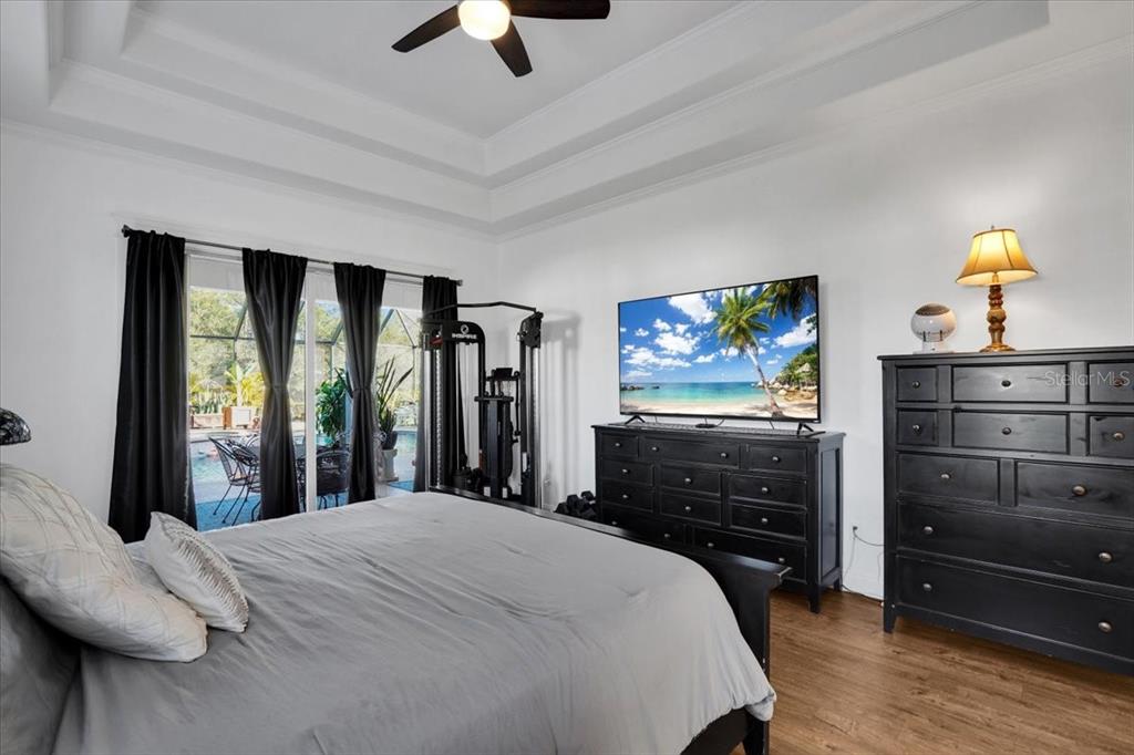 7601 226th Street East Bradenton, FL 34211 - Photo 25 of 50 a bedroom with a bed and a flat tv screen on dresser