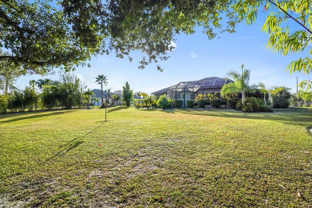 7601 226th Street East Bradenton, FL 34211 - Photo 46 of 50 a view of a large pool with lawn chairs under an umbrella