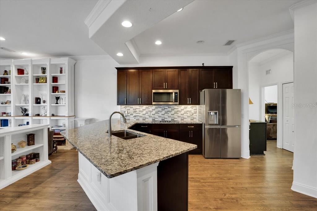 7601 226th Street East Bradenton, FL 34211 - Photo 8 of 50 a kitchen with stainless steel appliances granite countertop a table chairs and a refrigerator