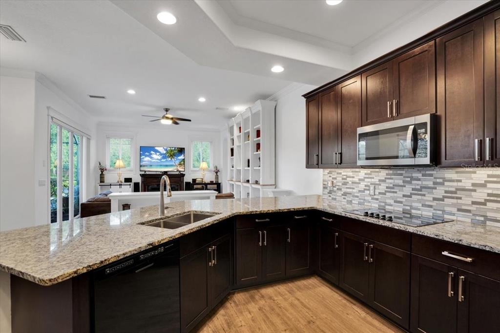 7601 226th Street East Bradenton, FL 34211 - Photo 10 of 50 a kitchen with granite countertop stainless steel appliances a sink stove top oven and cabinets