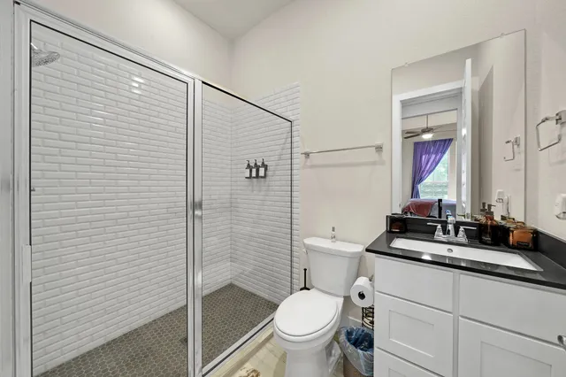 a bathroom with a granite countertop sink toilet and shower