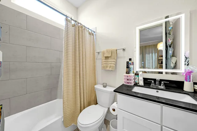 a bathroom with a sink a toilet a mirror and shower