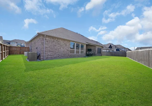 a view of a house with a big yard and large trees