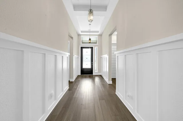 a view of a hallway with wooden floor and staircase