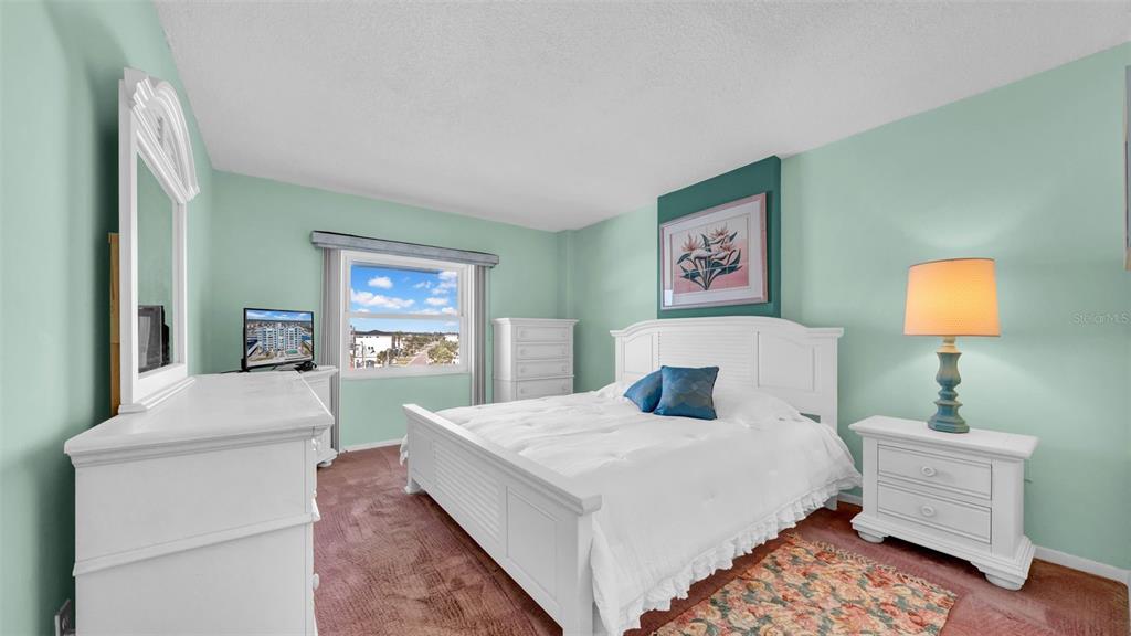 17400 Gulf Boulevard, Unit I4 North Redington Beach, FL 33708 - Photo 24 of 30 a bedroom with a bed and a lamp on dresser
