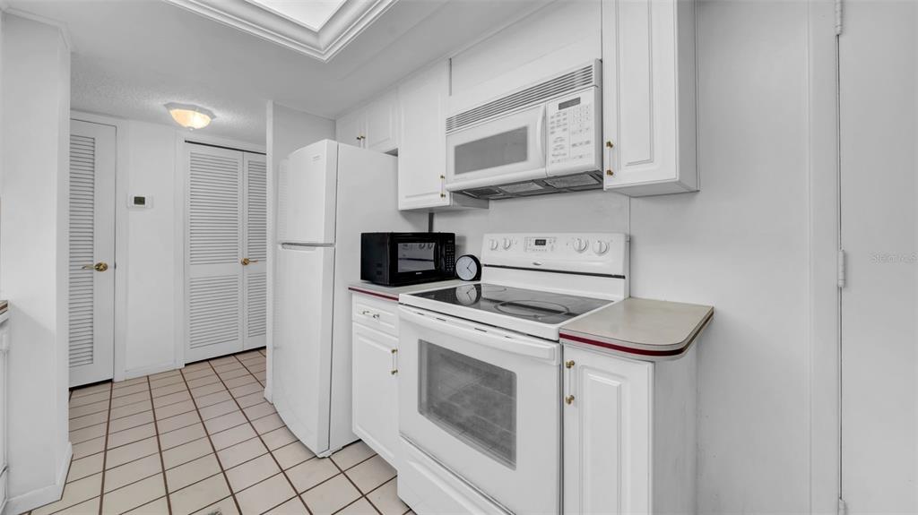 17400 Gulf Boulevard, Unit I4 North Redington Beach, FL 33708 - Photo 6 of 30 a kitchen with white cabinets stainless steel appliances and sink