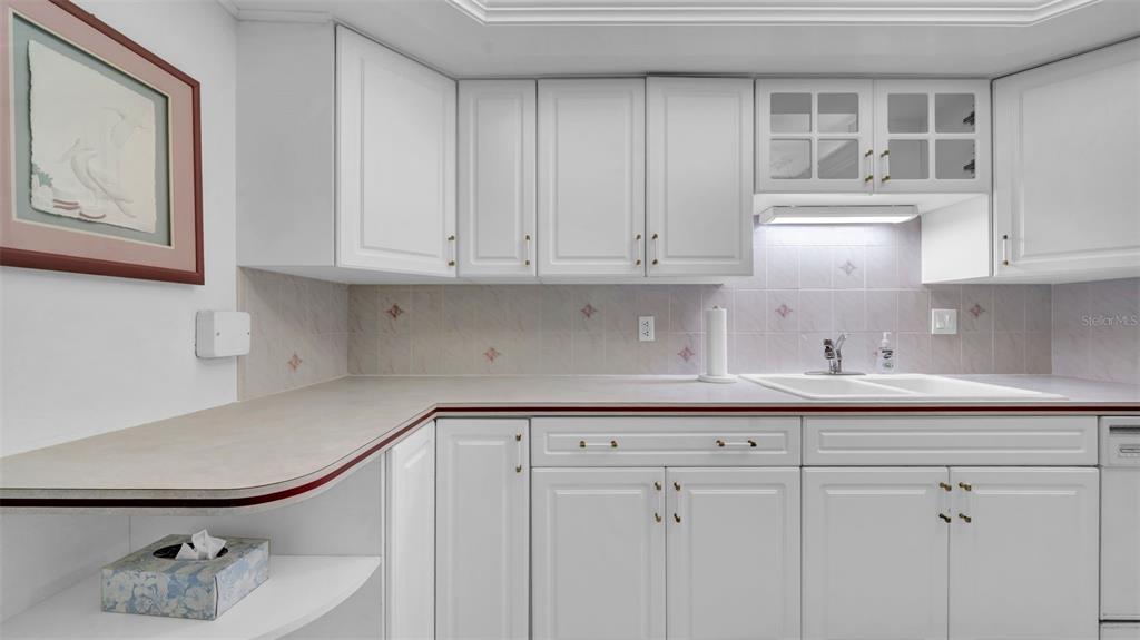 17400 Gulf Boulevard, Unit I4 North Redington Beach, FL 33708 - Photo 7 of 30 a kitchen with white cabinets and a sink