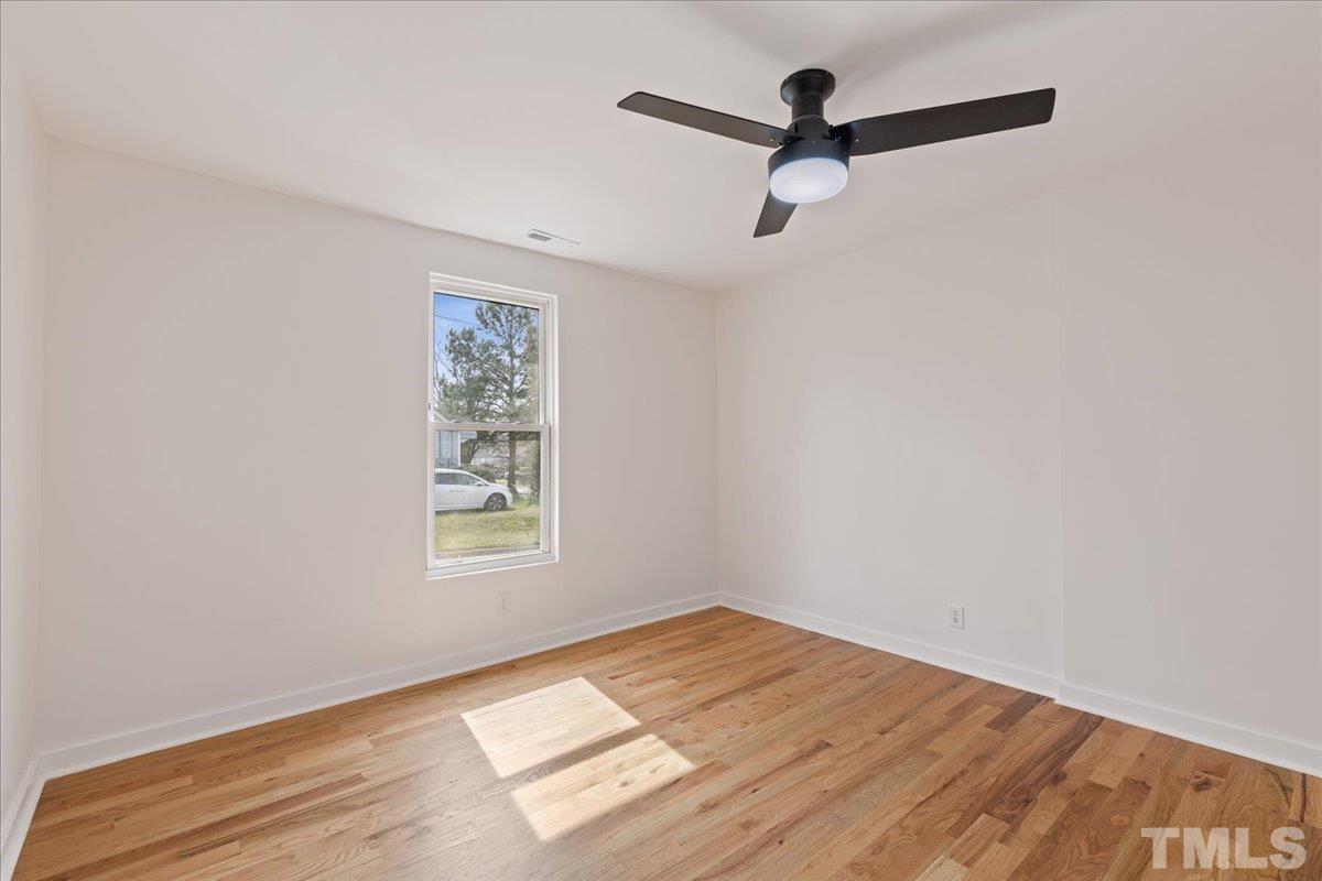 1100 Chester Street Durham, NC 27701 - Photo 27 of 43 an empty room with wooden floor ceiling fan and windows