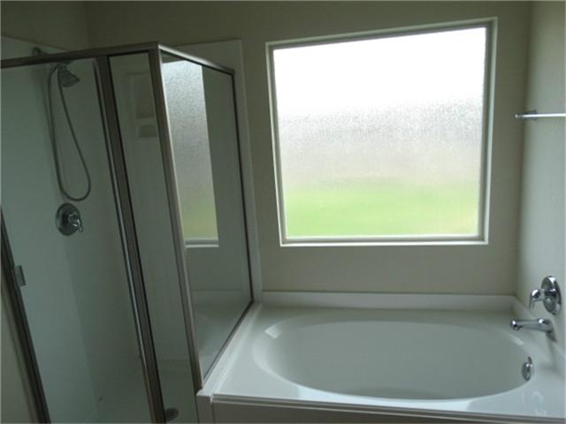 22618 Banter Point Lane Katy, TX 77449 - Photo 20 of 34 master bath featuring a spacious tub and separate glass-enclosed shower.